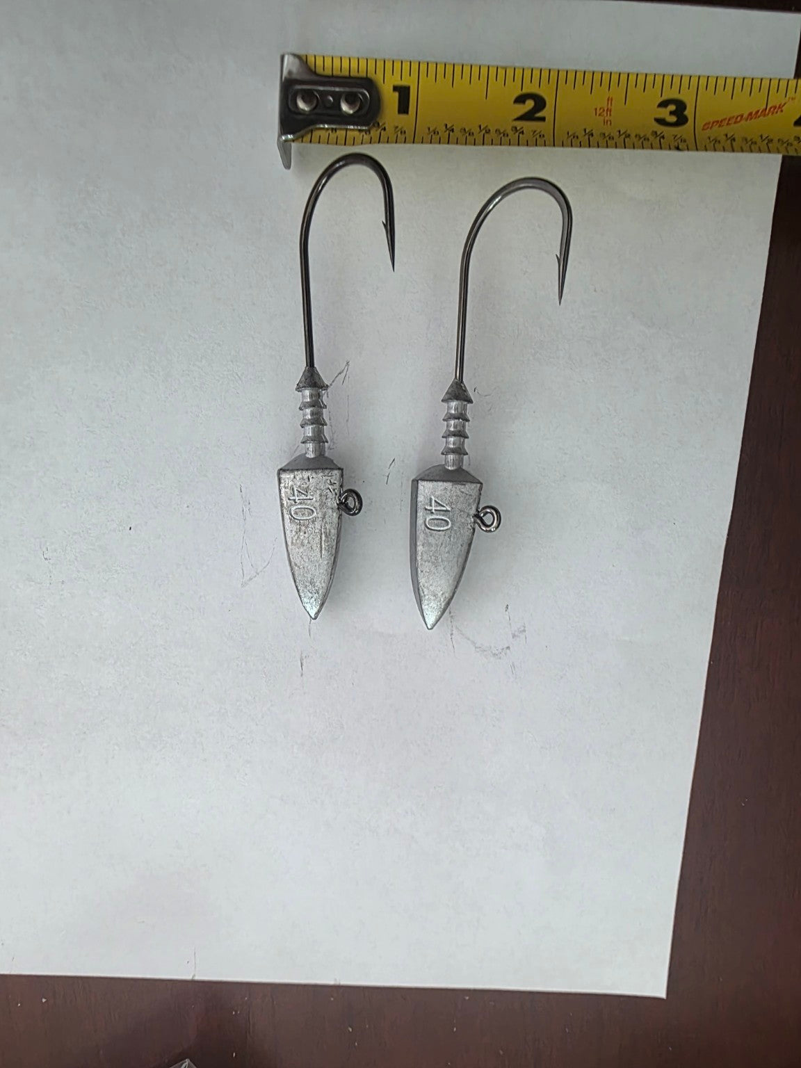Two unpainted 40 gram jig heads showing hook width